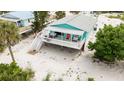 Beautifully elevated beach home with a covered porch and white railings at 9760 Little Gasparilla Island, Placida, FL 33946