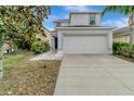 Two-story home with a two-car garage, landscaping, and a sidewalk at 1107 Seminole Sky Dr, Ruskin, FL 33570