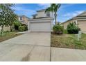 Two-story home with a two-car garage, landscaping, and a driveway at 1107 Seminole Sky Dr, Ruskin, FL 33570