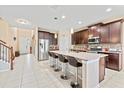 Modern kitchen features granite counters, stainless steel appliances, and a breakfast bar with seating at 11706 Gilmerton Dr, Riverview, FL 33579
