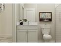 Well-lit half bathroom with neutral-toned walls, a modern vanity, an elegant mirror, and a low flow toilet at 11761 E 71St Ter, Palmetto, FL 34221