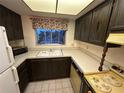 A vintage kitchen featuring wood cabinets, formica countertops, double sink and a window at 1200 37Th N St # 403, St Petersburg, FL 33713