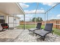 Relaxing outdoor patio area featuring stylish lounge chairs and a serene backyard view with privacy fence at 12279 Elmore Dr, Spring Hill, FL 34609