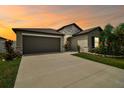 Charming single-Gathering home features a two-car garage, stone accents, and a beautifully landscaped front yard at 13603 Wild Ginger St, Riverview, FL 33579