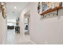 Hallway that leads to the living room and bedrooms, with neutral paint and tile flooring at 13603 Wild Ginger St, Riverview, FL 33579