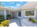 Front entrance features a welcoming doorway, manicured shrubs and decorative rock filled planter at 14204 Yacht Club Blvd, Seminole, FL 33776