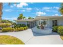 Close-up of single-story home featuring well-maintained landscaping, walkway, and decorative brickwork at 14204 Yacht Club Blvd, Seminole, FL 33776