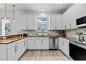 Modern kitchen featuring white cabinets, stainless steel appliances, and designer backsplash at 16206 Nottingham Park Way, Tampa, FL 33647