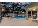 Inviting screened-in pool with patio seating and ambient lighting perfect for outdoor entertaining at 16206 Nottingham Park Way, Tampa, FL 33647