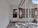 Covered front porch with a white storm door, diamond-shaped shutters, and decorative wrought iron features at 2222 Euclid N Cir, Clearwater, FL 33764