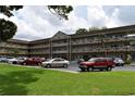 Angle view of a multi-Gathering condominium building with a landscaped grass lawn and car parking at 2463 Brazilia Dr # 43, Clearwater, FL 33763