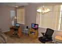 A living room featuring window blinds, ceiling fan, tile floors, and a desk at 2463 Brazilia Dr # 43, Clearwater, FL 33763