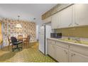 Kitchen with dining area featuring ample cabinets, refrigerator, and vintage style at 2724 W Henry Ave, Tampa, FL 33614
