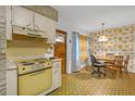 Cozy kitchen featuring a stove, classic cabinets, and a dining area at 2724 W Henry Ave, Tampa, FL 33614