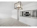 Living room and kitchen featuring white walls, modern light fixture, and tile flooring at 3102 W Horatio St # 13, Tampa, FL 33609