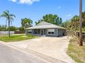 View of the home with gray siding and a well-manicured lawn on a sunny day at 366 12Th Ave, Indian Rocks Beach, FL 33785