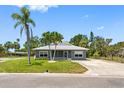 A well-maintained home with a lovely lawn, palm trees and gray paint at 366 12Th Ave, Indian Rocks Beach, FL 33785