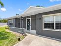Gray house with a screened porch, well-manicured lawn, and decorative front door at 366 12Th Ave, Indian Rocks Beach, FL 33785