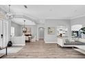 Bright and spacious living room with hardwood floors, modern lighting, and an open floor plan at 3716 Janus Way, Palm Harbor, FL 34685
