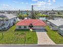 Aerial view of a single-story home with a red tile roof, attached garage, lawn and a waterfront location at 4274 Deleon Dr, Hernando Beach, FL 34607