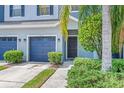 Close-up of townhome with blue garage doors, inviting front door, and mature landscaping at 4528 Amberly Oaks Ct, Tampa, FL 33614