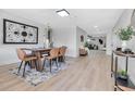 Modern dining room featuring a wooden table with tan chairs, a patterned rug, and light wood floors at 4624 83Rd Terrace N, Pinellas Park, FL 33781