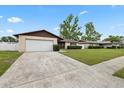 Single-story home with a well-kept lawn, mature tree, and an attached one-car garage at 5213 Burr Pl, Seffner, FL 33584