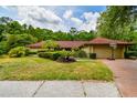 Charming single-story home featuring a well-manicured lawn and lush, mature landscaping at 5702 Ainsworth W Ct, Tampa, FL 33647