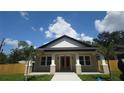Attractive single-story home featuring a covered porch, palm trees, and new landscaping at 7013 N 15Th St, Tampa, FL 33610