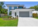 Contemporary two-story home showcasing a two-car garage, clean lines, and fresh landscaping at 715 W Peninsular St, Tampa, FL 33603