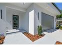 Close up of the entrance featuring a modern door, textured stucco, and an attached garage at 715 W Peninsular St, Tampa, FL 33603