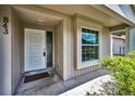 Inviting front porch featuring a white door and a large window with a glimpse of the neighborhood at 843 Greenfield Dr, Palm Harbor, FL 34684