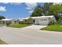 Well-maintained home featuring a crisp, white exterior, bright turquoise accents, and lush landscaping at 9639 Mainlands E Blvd, Pinellas Park, FL 33782