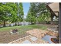 A peaceful backyard with a fire pit and water view at 1010 Elm Grove Ln, Valrico, FL 33596
