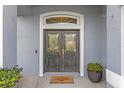 Elegant double front doors with decorative glass and transom window, creating a welcoming entrance at 10502 Brentford Dr, Tampa, FL 33626