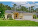 Inviting single-story home with a neatly kept lawn, arched entryway, paver driveway, and a two car garage at 13038 Royal George Ave, Odessa, FL 33556