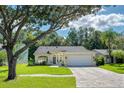 Charming single-story home with a well-manicured lawn, lovely landscaping and a brick paved driveway leading to a two-car garage at 13038 Royal George Ave, Odessa, FL 33556