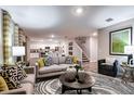 Cozy living room with hardwood floors, sofas, modern décor, and an open floor plan to the kitchen at 13040 Wellspring Dr, Lithia, FL 33547