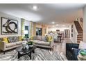 Bright living room featuring hardwood floors, modern furniture, and an open floor plan to the kitchen at 13040 Wellspring Dr, Lithia, FL 33547
