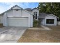 A two-story home with a two-car garage, neutral exterior paint and landscaping at 13218 Parkhurst Ct, Riverview, FL 33569