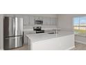 Beautiful kitchen with stainless appliances, a large island with sink and gray cabinets at 14711 Summer Branch Dr, Lithia, FL 33547