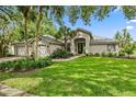 Charming single-story home with a well-manicured lawn, mature landscaping, and a three-car garage at 16804 Windsor Park Dr, Lutz, FL 33549