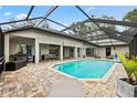 Screened-in pool area with ample seating, brick pavers and covered patio, perfect for entertaining at 16804 Windsor Park Dr, Lutz, FL 33549