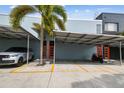 Modern condo with covered parking, palm trees, and vibrant orange entry doors; convenient and stylish living at 2505 W Azeele St, Tampa, FL 33609