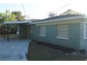 View of the rear exterior with a covered parking area and simple landscaping at 3421 E Powhatan Ave, Tampa, FL 33610