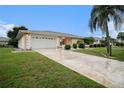 Lovely single-story home with a clean driveway, well-kept lawn, and a two-car garage at 406 S Pebble Beach Blvd, Sun City Center, FL 33573