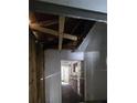 Interior home view with damaged ceiling and open doorway leading to kitchen with wood cabinets at 4207 E Henry Ave, Tampa, FL 33610