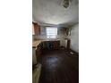 Incomplete kitchen featuring rustic wood countertops, aged wood cabinets, and a single-basin sink with a window view at 4207 E Henry Ave, Tampa, FL 33610