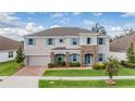 Charming two-story home with stone accents, a brick driveway, and a well-maintained lawn at 5416 Camberwell Ln, Riverview, FL 33578