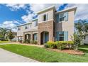 Two-story home with blue shutters and a stone accented entrance stands on a well-maintained lawn at 5416 Camberwell Ln, Riverview, FL 33578
